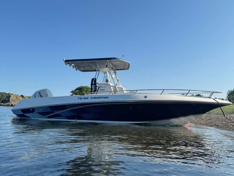 Fountain Sportfish 25 CC med T-top og Evinrude-motor ved stranden